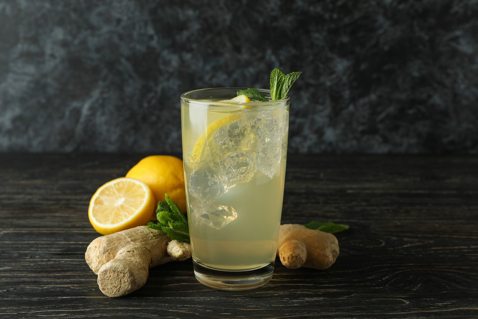 glass-of-ginger-lemon-drink-and-ingredients-on-wooden-table.jpg